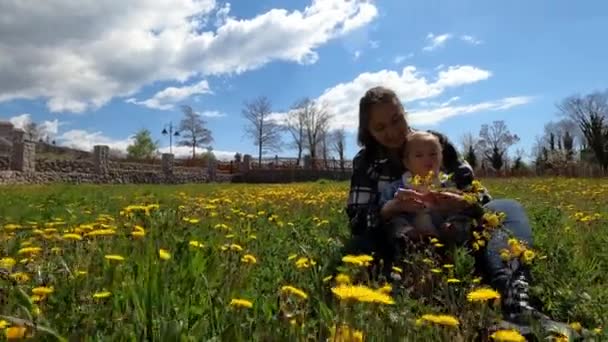 Little Girl Sits Her Mother Arms Weaving Wreath Yellow Dandelions — Vídeo de Stock