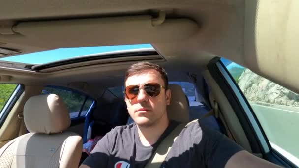 Young Man Sunglasses Drives Mountain Road Car Open Sunroof High — Stockvideo