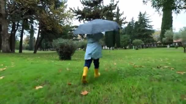 Liten Flicka Gummistövlar Springer Ett Paraply Det Gröna Gräset Parken — Stockvideo
