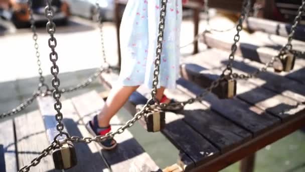 Little Girl Walks Suspension Bridge Stepping Bars Holding Handrail High — Stockvideo