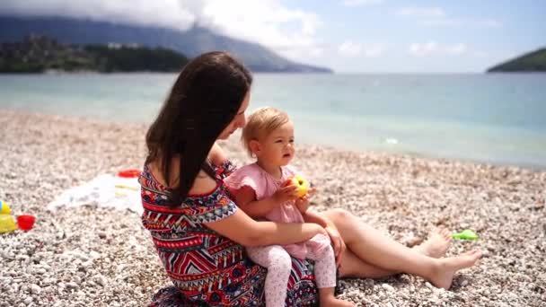 Gadis Kecil Dengan Apel Duduk Pangkuan Ibunya Pantai Dan Menunjuk — Stok Video