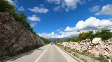 Car drives along the highway along the mountain overlooking the settlement in the valley. High quality 4k footage