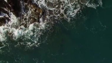 Sea waves roll on the rocks, raising splashes. High quality 4k footage
