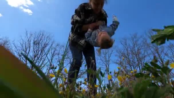 Mother Swings Little Girl Her Arms Holding Her Upside Flowery — Stok video