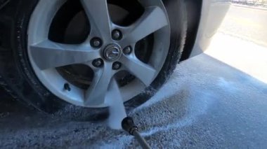 Wheel of the car is washed with a hose under pressure at the sink. High quality 4k footage