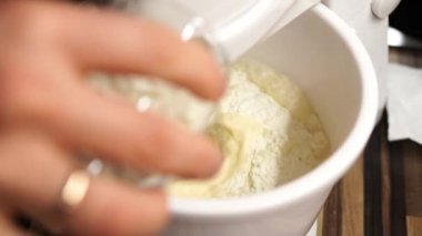 Cook adds flour to the mixer bowl to the whipping dough. High quality 4k footage