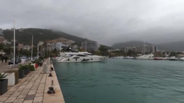 Rain and fog over the mountains of a resort town with moored yachts off the coast. High quality 4k footage