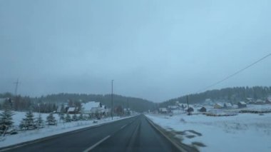 Snow-covered road in a small town at the foot of the mountains. Zabljak, Montenegro. High quality 4k footage