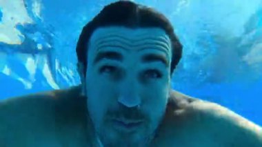 Man with open eyes dives into the pool and swims out. High quality 4k footage
