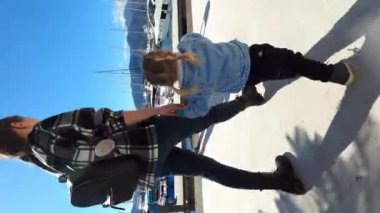 Mom and little girl come to the edge of the pier and look at the yachts. High quality 4k footage