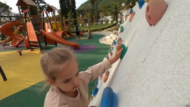 Little Girl Climbs Climbing Wall Clinging Ledges Her Hands High — Stockvideo