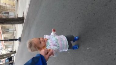 Little girl runs along an asphalt road holding her father hand. High quality 4k footage