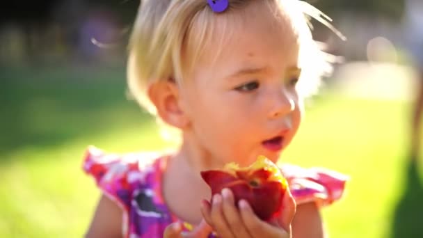 Little Girl Eating Juicy Peach While Standing Sunny Lawn High — ストック動画