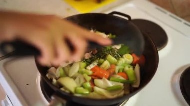 Woman stirs stewing vegetables with a spoon in a frying pan. High quality 4k footage
