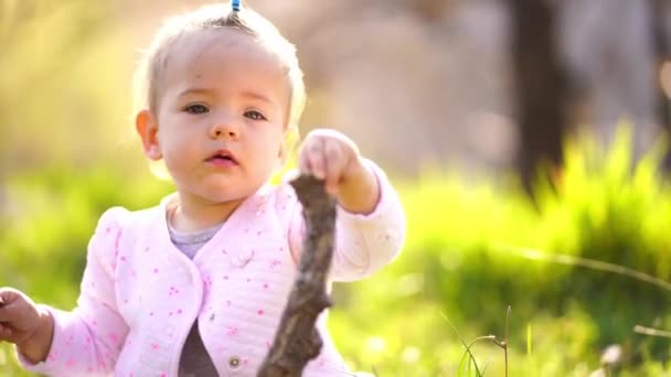 Little Girl Sits Green Lawn Tries Gnaw Stick High Quality — Stock videók