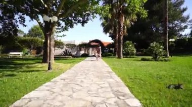Mom runs after a little girl walking along a path in the park. High quality FullHD footage