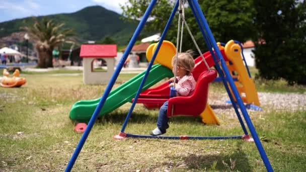 Little Girl Sitting Swing Twitching Her Legs High Quality Footage — Wideo stockowe