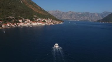 Motorboat sails along the Kotor Bay to the coast of Perast. Drone. High quality 4k footage