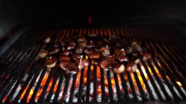 Bunch of chestnuts are being prepared on a grate in a brick oven. High quality 4k footage