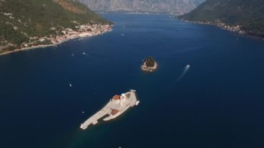 Boats sail along the Bay of Kotor past the island of Gospa od Skrpjela. Top view. High quality 4k footage