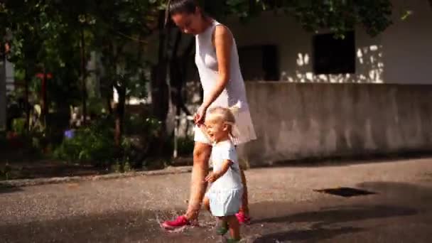 Маленькая Девочка Мамой Держащейся Руки Бегущей Через Лужи Брызги Высококачественные — стоковое видео