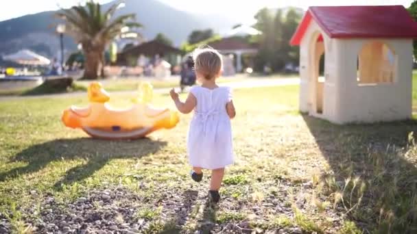 Little Girl Walks Green Grass Swing Back View High Quality — Stockvideo