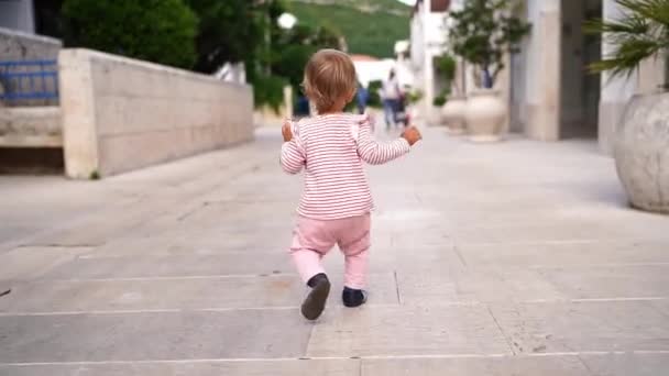 Маленька Дівчинка Йде Вулиці Махаючи Руками Вид Ззаду Високоякісні Fullhd — стокове відео