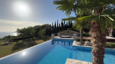 Swimming pool with turquoise water in the garden with palm trees. High quality 4k footage