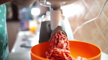 Cook twists the minced meat in an electric meat grinder into a bowl. High quality 4k footage