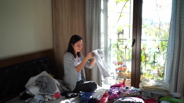 Smiling Housewife Sorts Clean Linen Piles While Sitting Bed High — Video Stock