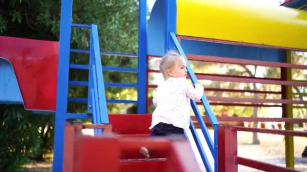 Little Girl Climbs Steps Slide Holding Handrail High Quality Footage — Stockvideo