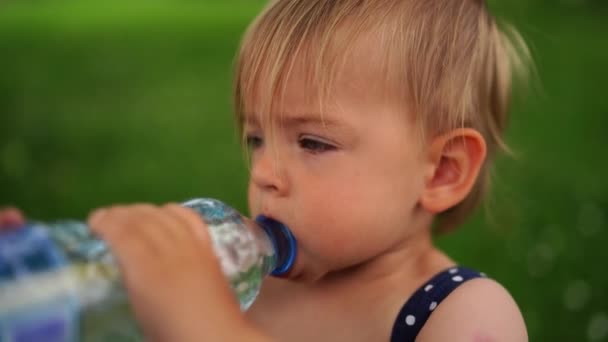 Niña Bebiendo Agua Una Botella Sosteniéndola Con Ambas Manos Imágenes — Vídeos de Stock