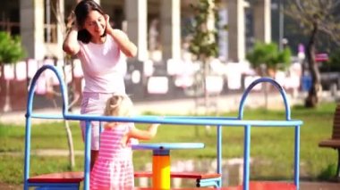 Annem oyun parkında atlıkarıncada duran bir kıza biner. Yüksek kalite 4k görüntü
