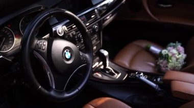 Bouquet of flowers lies on the passenger seat of a BMW car. High quality FullHD footage