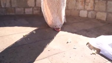 Bride in a white dress walks on the tiled floor. Cropped. High quality FullHD footage