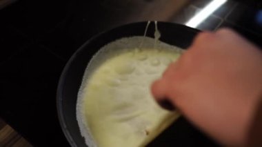 Chef flips the pancake in the pan with his hand and spatula. High quality 4k footage