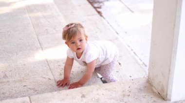 Little girl crawling backwards down the stairs. High quality 4k footage