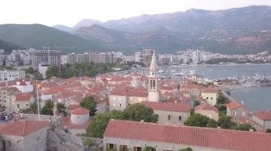 View of the old town of Budva against the backdrop of modern high-rise buildings. Drone. High quality 4k footage