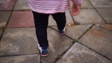 Small kid walks on the tiles, waving his arms. Cropped. High quality FullHD footage