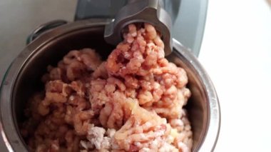 Electric meat grinder fills a large bowl with minced meat. High quality 4k footage