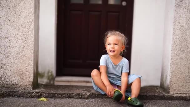 Little Girl Sits Threshold House Yard Takes Her Flip Flops — Video Stock