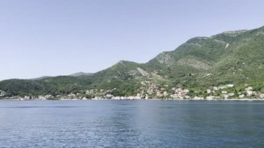View from the sea to the green mountains and the resort town on the coast. High quality 4k footage