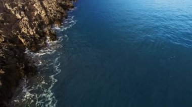 Blue sea washes a rocky secluded coast. Aerial view. High quality 4k footage