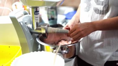 Aşçı sosis pişirmek için kovanı kıyma makinesinin eklentisine koyar. Yüksek kalite 4k görüntü
