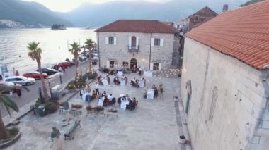 Festive tables are set in the courtyard between the old houses. Perast, Montenegro. High quality 4k footage