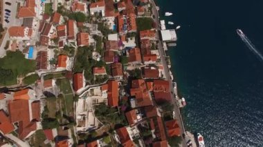 Perast 'teki eski evlerin kırmızı çatıları ve avluda yüzme havuzları. Drone. Yüksek kalite 4k görüntü
