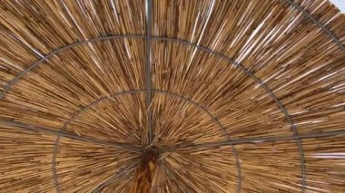 Straw solar umbrella against the blue sky. High quality 4k footage