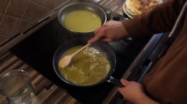 Chef dissolves the butter in a frying pan with caramel stirring with a spatula. High quality 4k footage