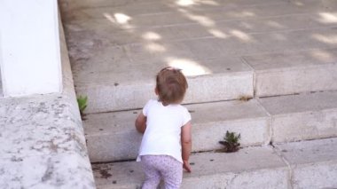 Little girl crawled down the steps and walked across the tiles. High quality 4k footage