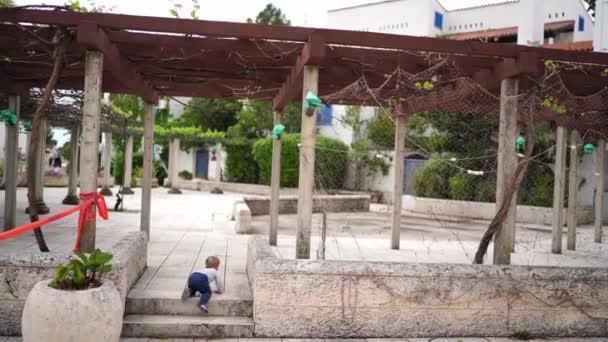Κοριτσάκι Σέρνεται Στα Σκαλοπάτια Της Πέργκολα Και Σηκώνεται Στα Πόδια — Αρχείο Βίντεο